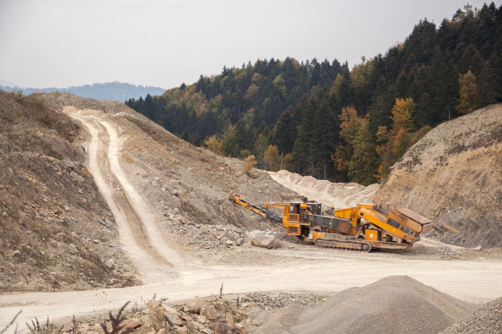 Stone crusher machine working in an open pit quarry